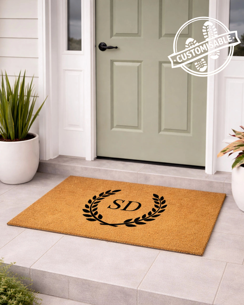 Doormat with initials 'S&D' on a light gray floor in front of a green door. [VARIANT: TWO INITIALS / NO BORDER]