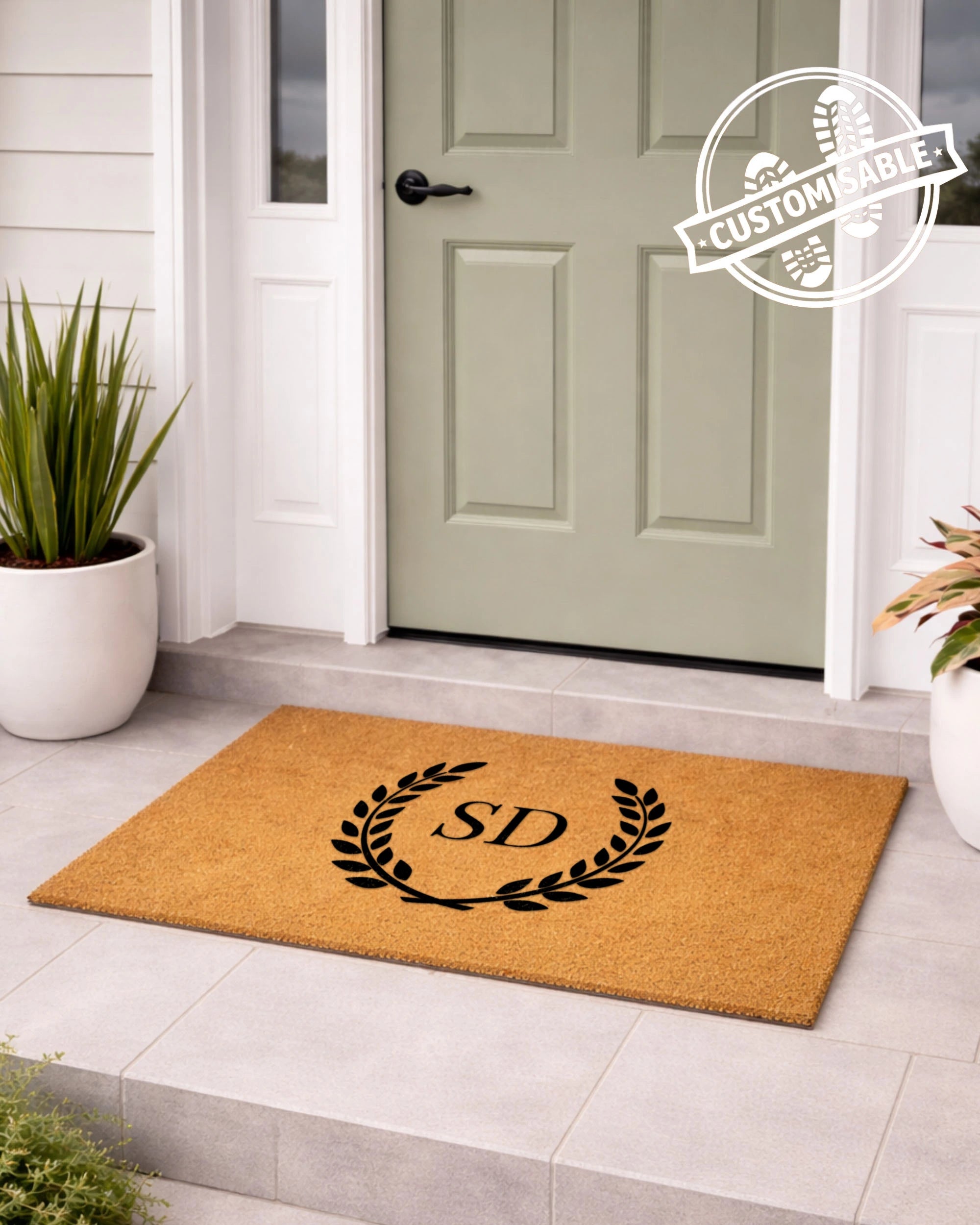 Doormat with initials 'S&D' on a light gray floor in front of a green door. [VARIANT: TWO INITIALS / NO BORDER]