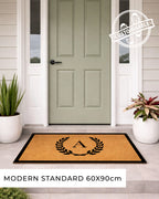 Doormat with a monogram in front of a green door on a porch. [VARIANT: SINGLE INITIAL / BORDER]