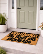 Doormat with humorous text in front of a house entrance [VARIANT: DOGS / DICKHEADS]