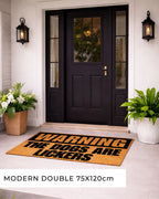Front door with a doormat warning 'Warning: The dogs arelickers' and potted plants on either side. [VARIANT: DOGS / LICKERS]