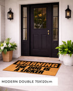 Front door with a doormat warning 'The dog is a licker' and decorative plants. [VARIANT: DOG / LICKER]