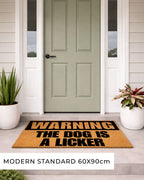 Doormat with 'Warning: The Dog is a Licker' text in front of a green door. [VARIANT: DOG / LICKER]