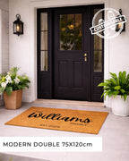 Front door with a personalized doormat and decorative plants. [VARIANT: STANDARD-EST]